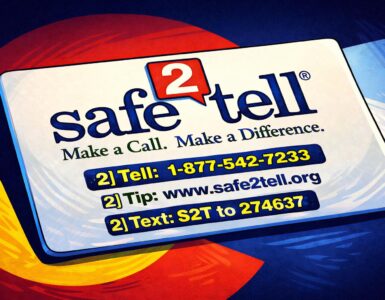 A high school hallway with a police officer talking to an administrator near lockers